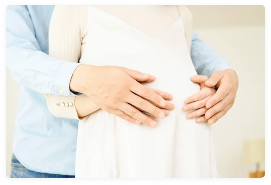 お腹を抱える夫婦の写真